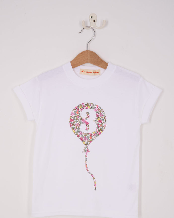 A 3rd birthday white t-shirt with a balloon and number 3 on it made from Liberty Floral print fabric.