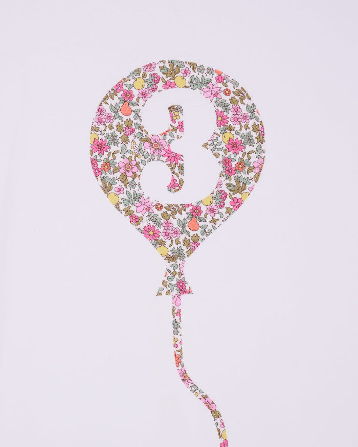 A close up of a 3rd birthday white t-shirt with a balloon and number 3 on it made from Liberty Floral print fabric.