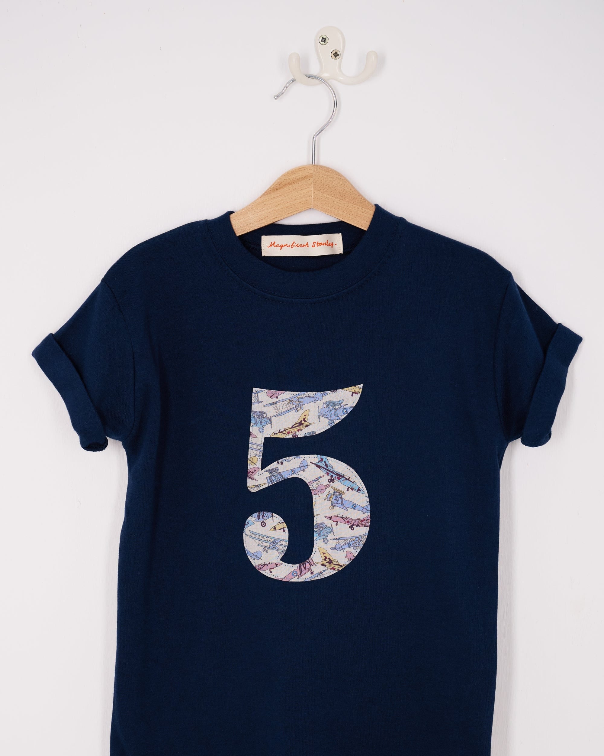A navy cotton t-shirt with a number 5 sewn on the front made from Tom's Jet plane Liberty fabric.