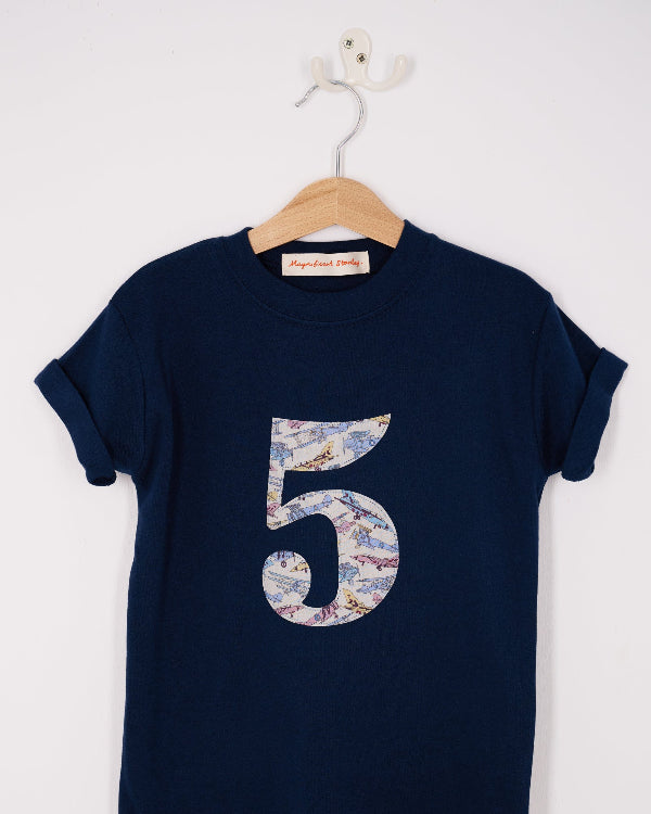 a Magnificent Stanley kids Number kids cotton Navy T-Shirt in Tom's Jet Liberty Print hanging on a hanger