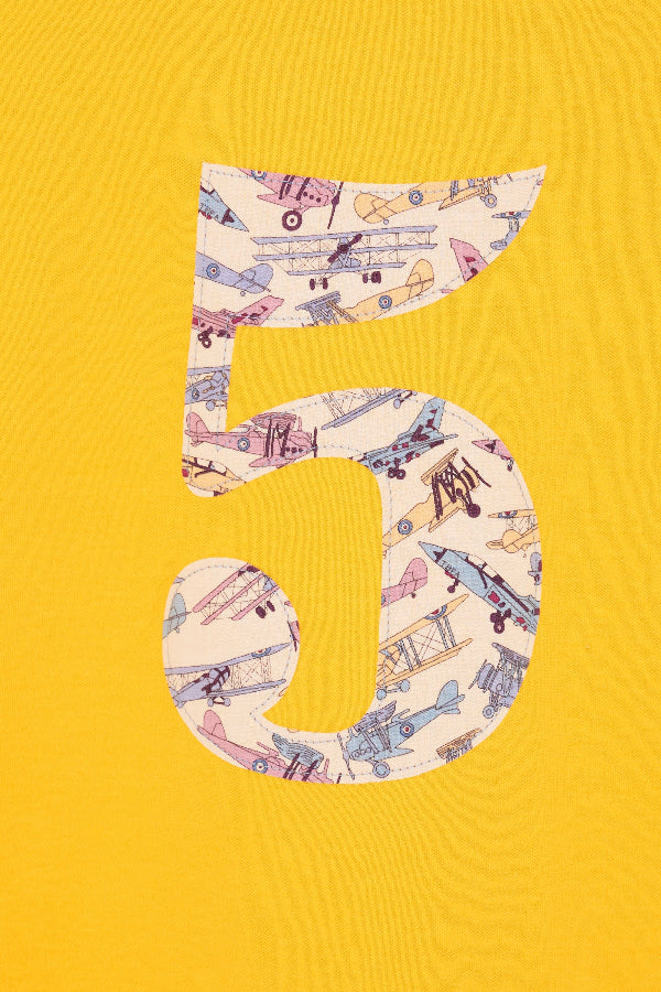 a yellow cotton t-shirt with a number 5 sewn on the front made from Tom's Jet plane Liberty fabric.