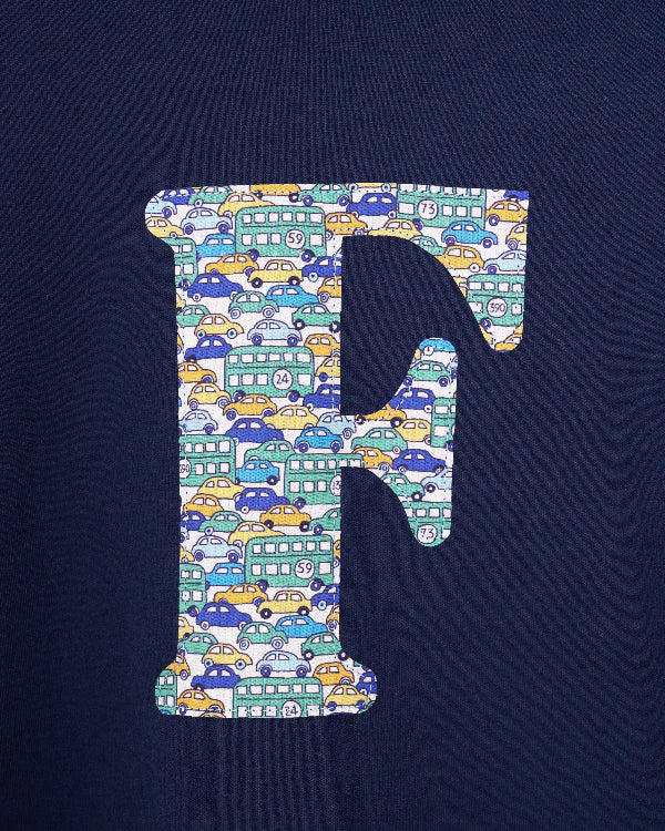 A case up of a personalised cotton long sleeve navy t-shirt with an initial on the front made from Liberty cars print fabric.