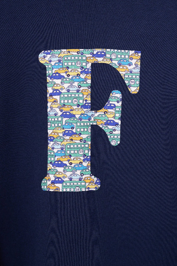 A case up of a personalised cotton long sleeve navy t-shirt with an initial on the front made from Liberty cars print fabric.