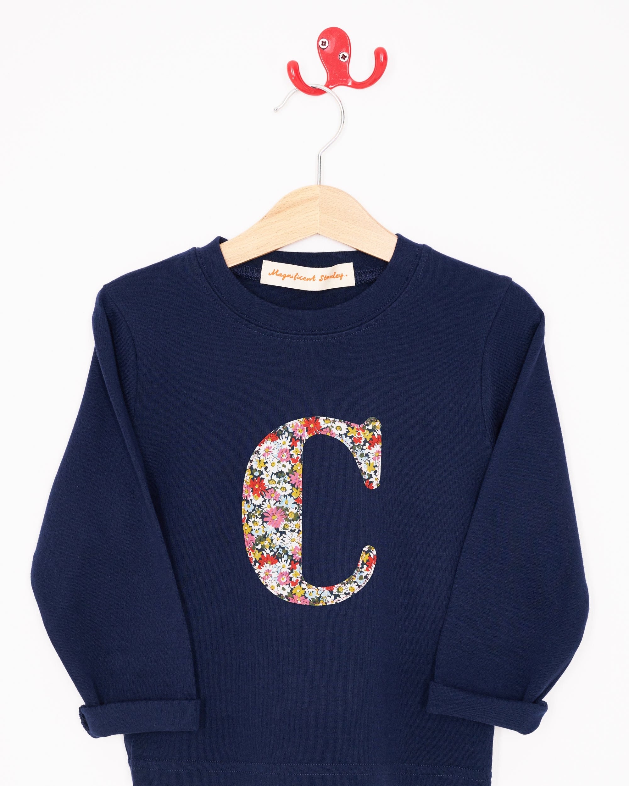 A personalised cotton navy long sleeve t-shirt with her initial on the front made from Libby a floral Liberty print.