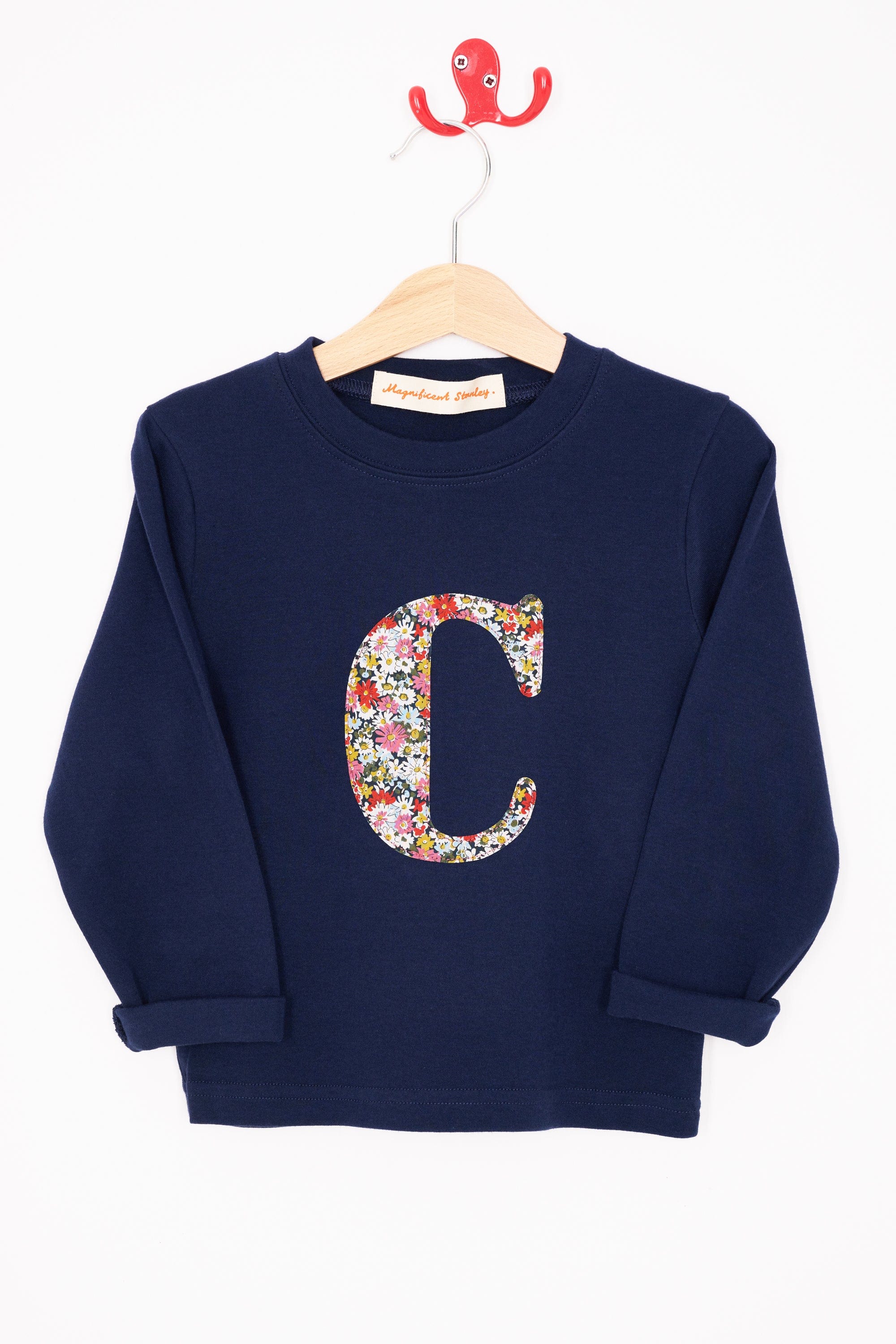 A personalised cotton navy long sleeve t-shirt with her initial on the front made from Libby a floral Liberty print.