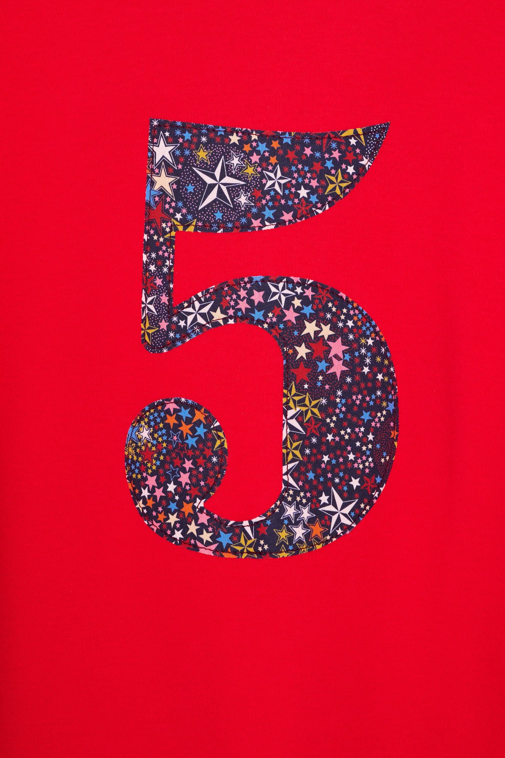 A close up of the appliqué on a red birthday t-shirt with the number 5 sewn onto it in Liberty Adelajda star print fabric.