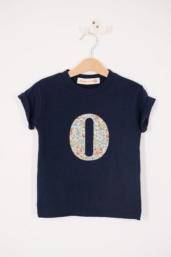 a personalised kids navy t-shirt with an initial cut from nazanin liberty floral print on the front.
