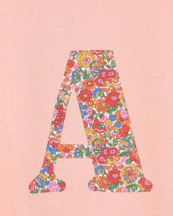 a personalised dusty pink sweatshirt with an initial on in floral Nell Annie May Liberty print on the front. A close up of the appliqué sewing.