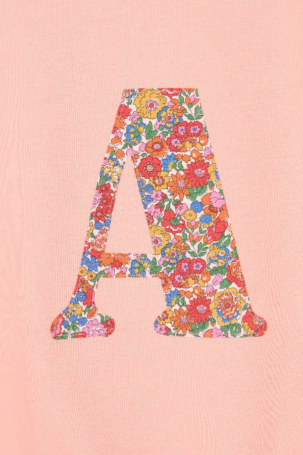 a personalised dusty pink sweatshirt with an initial on in floral Nell Annie May Liberty print on the front. A close up of the appliqué sewing.