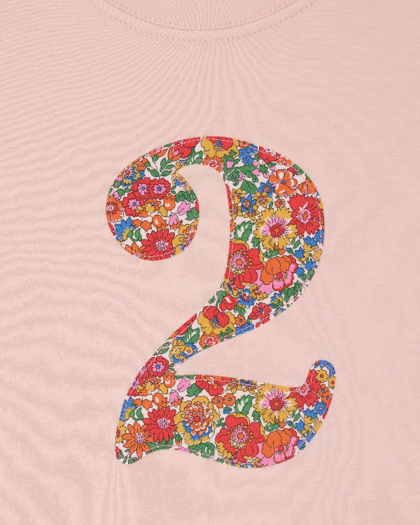 a pale pink t-shirt with a Liberty Nell Annie and May floral number '2' on the front