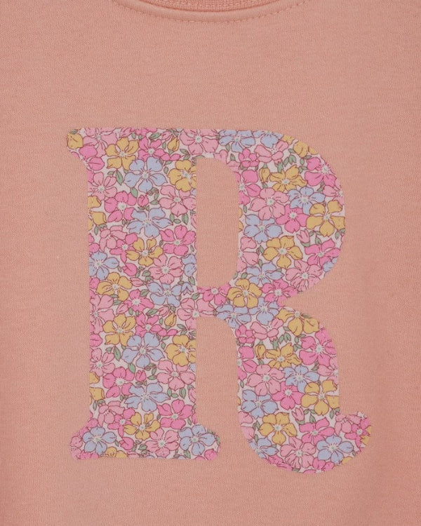 a personalised dusty pink sweatshirt with an initial on in floral Sadie Rose Liberty print on the front. A close up of the appliqué sewing.
