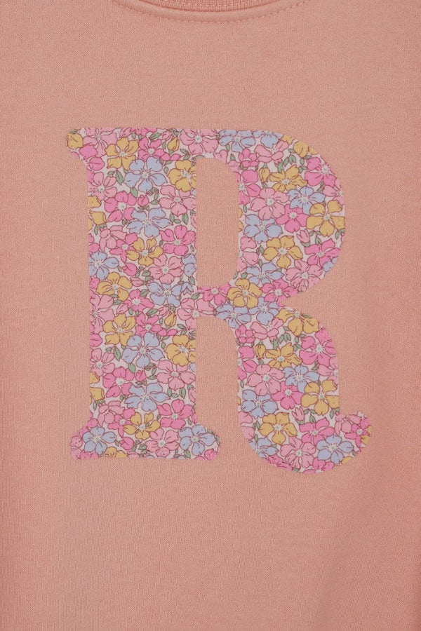 a personalised dusty pink sweatshirt with an initial on in floral Sadie Rose Liberty print on the front. A close up of the appliqué sewing.