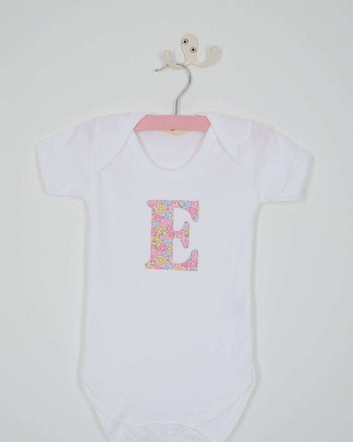 a personalised bodysuit baby grow with an initial cut from floral sadie roseLiberty print