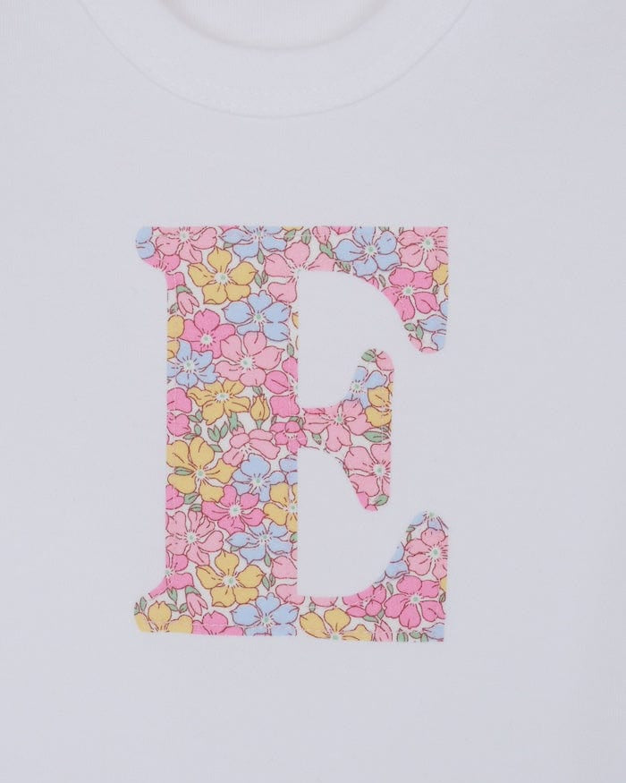 a personalised bodysuit baby grow with an initial cut from floral sadie roseLiberty print. A close up of the appliqué stitching.