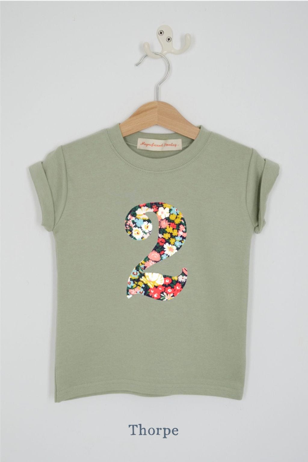 a number 2nd birthday kids sage green t-shirt with a number cut from thorpe floral liberty print on the front.
