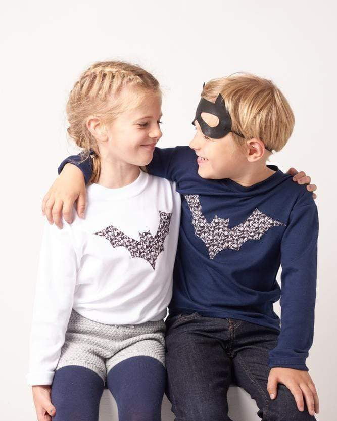 A boy and a girl in white and navy cotton tees with bats on made from Liberty Alba print fabric for halloween.