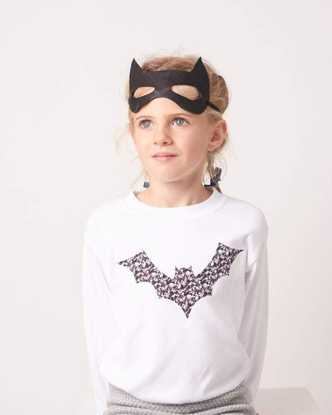 A girl in white cotton tee with a bat on made from Liberty Alba print fabric for halloween.