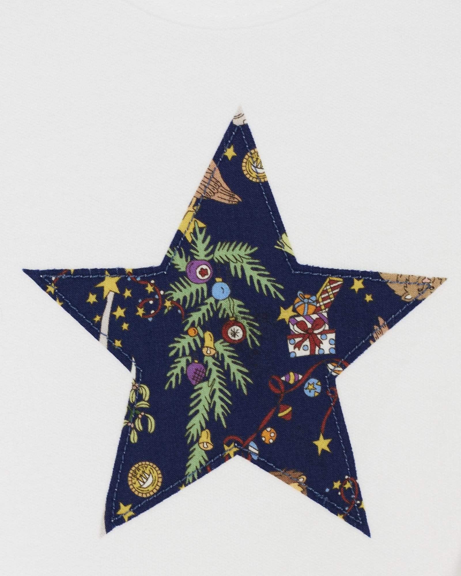 A close up of white bodysuit babygrow with a Liberty Christmas print festive star sewn on the front.