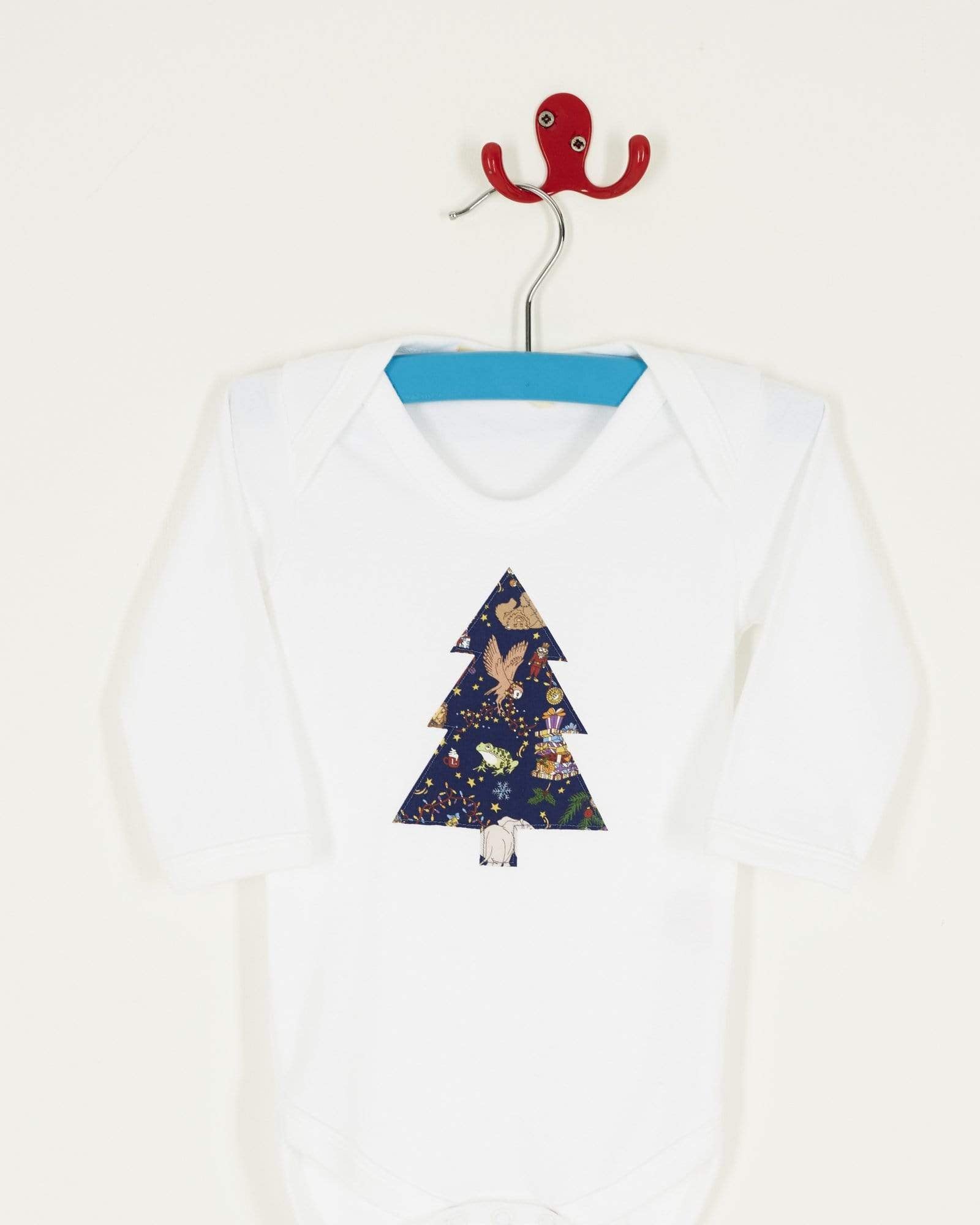 A white bodysuit babygrow with a Liberty Christmas print Christmas tree sewn on the front.