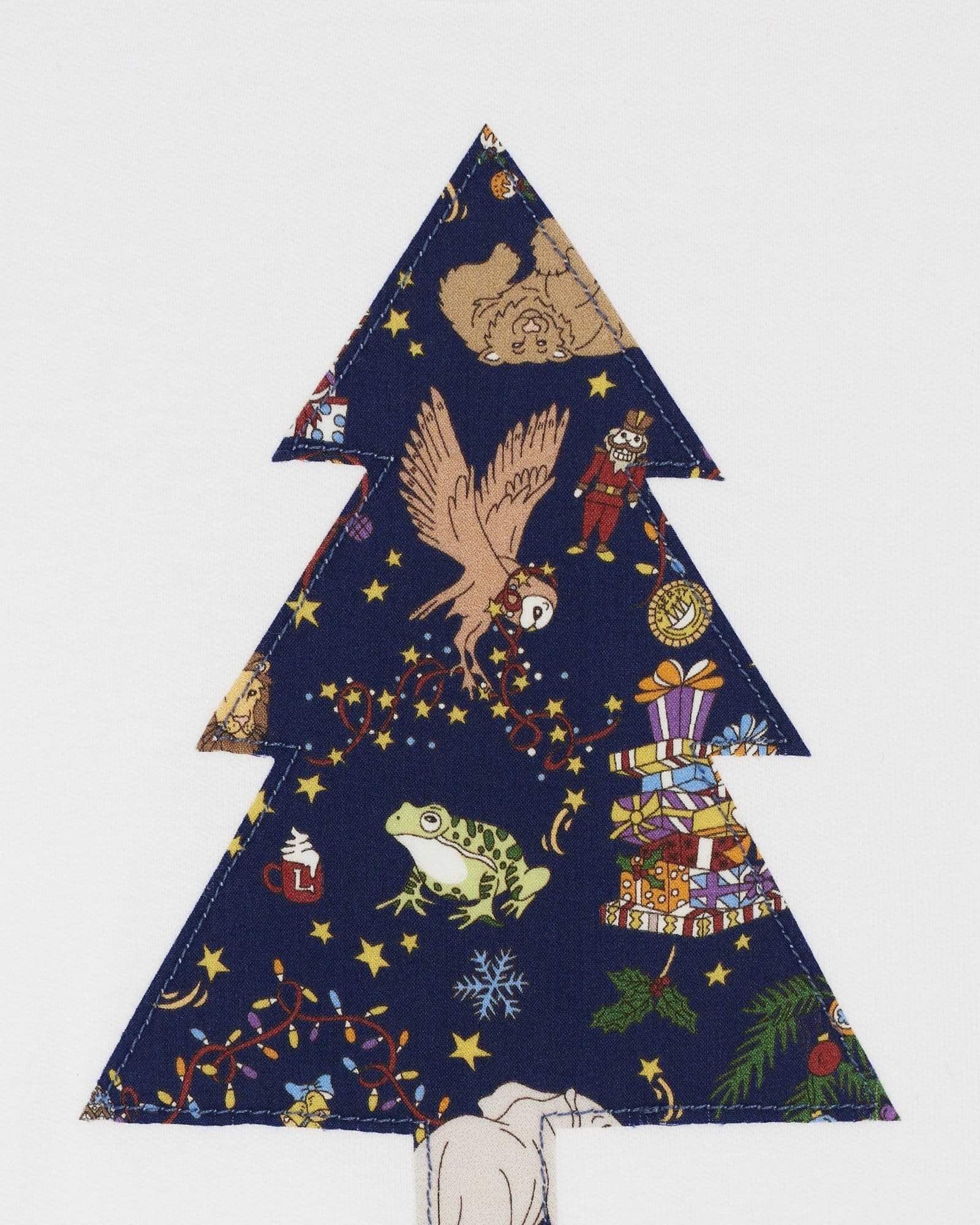 A close up of a white bodysuit babygrow with a Liberty Christmas print Christmas tree sewn on the front.