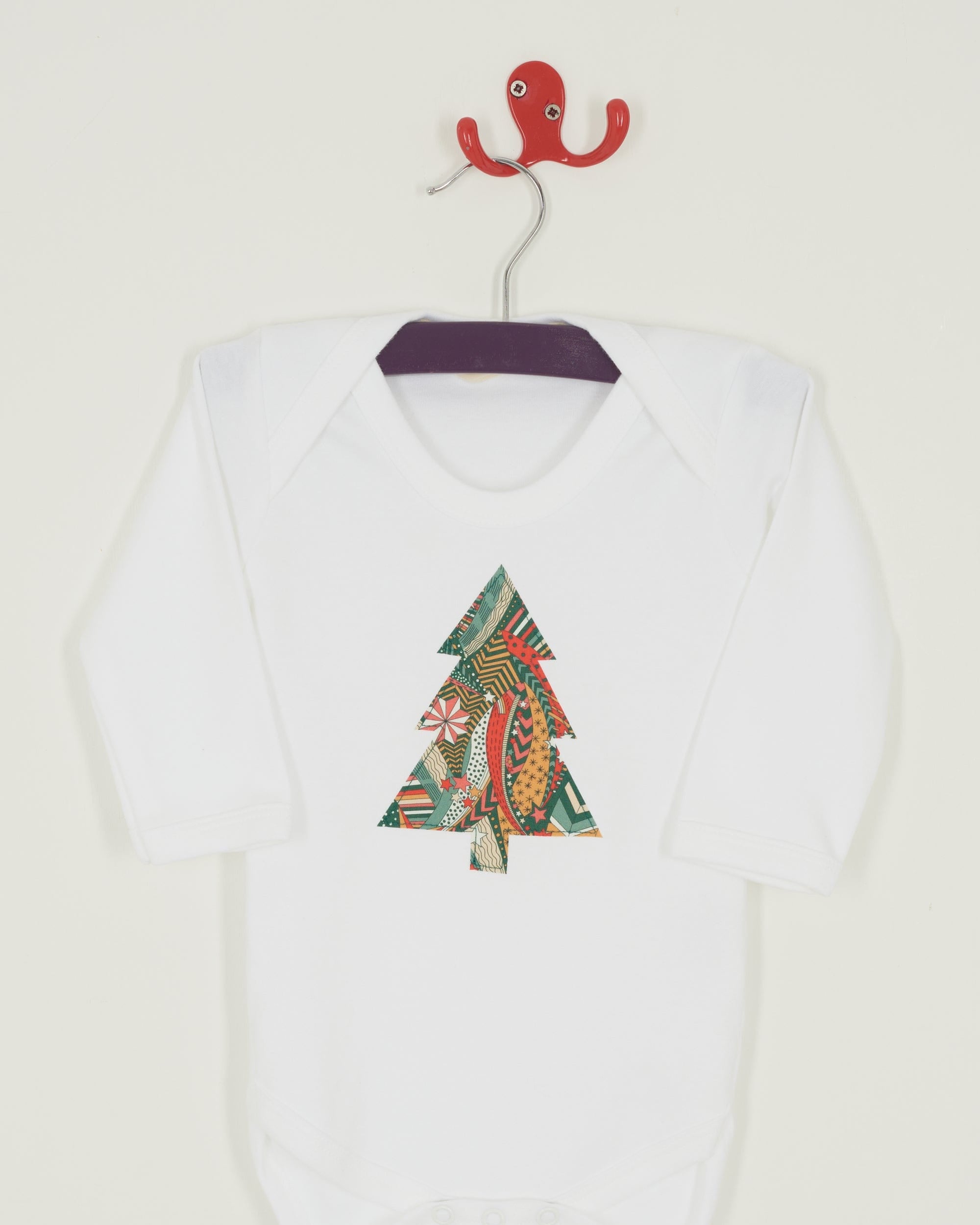 A white bodysuit babygrow with a Liberty My Little Star print festive Christmas tree sewn on the front.