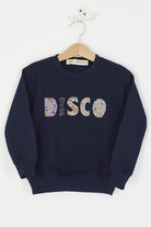 a Magnificent Stanley navy sweatshirt with the word DISCO Mixed Liberty Print sewn onto the front