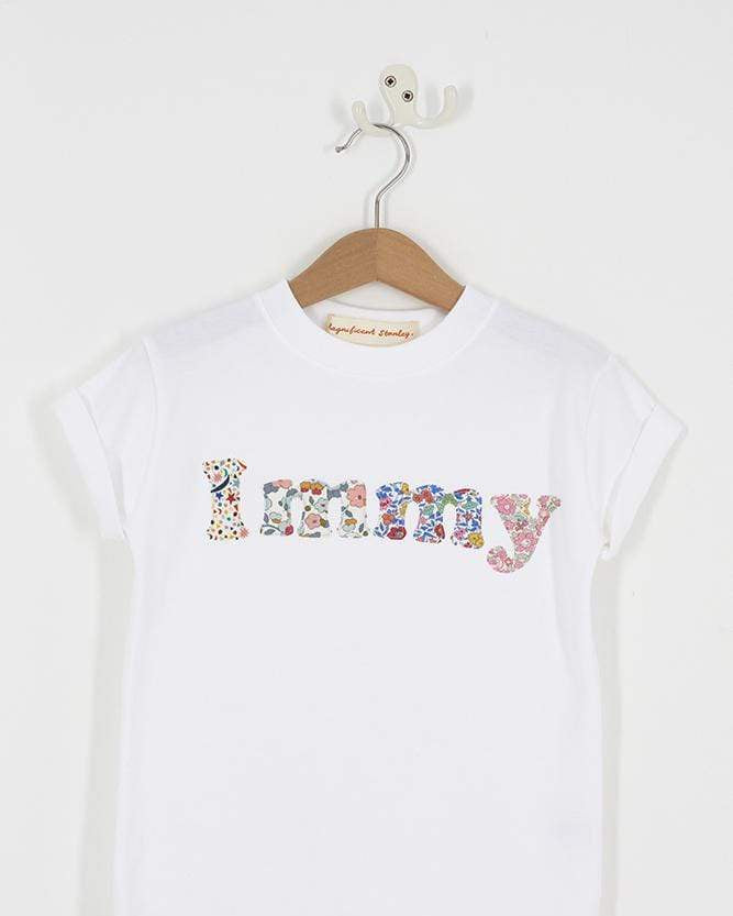 A close up of a personalised white t-shirt with her name on in a mix of Liberty prints.