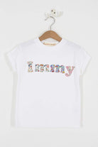 A close up of a personalised white t-shirt with her name on in a mix of Liberty prints.