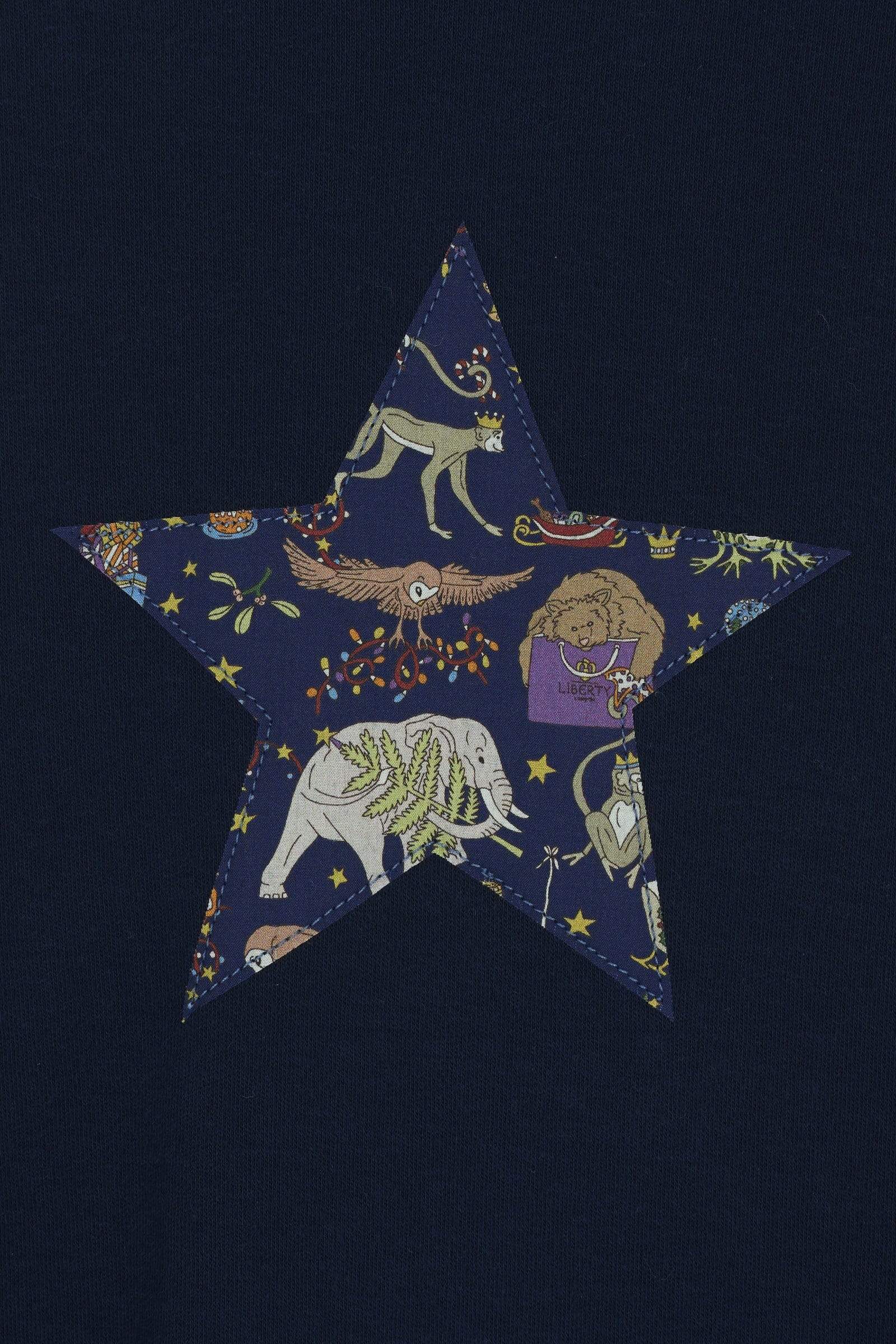 A navy long sleeve christmas t-shirt with a festive star on the front made from Liberty Christmas print on the front.