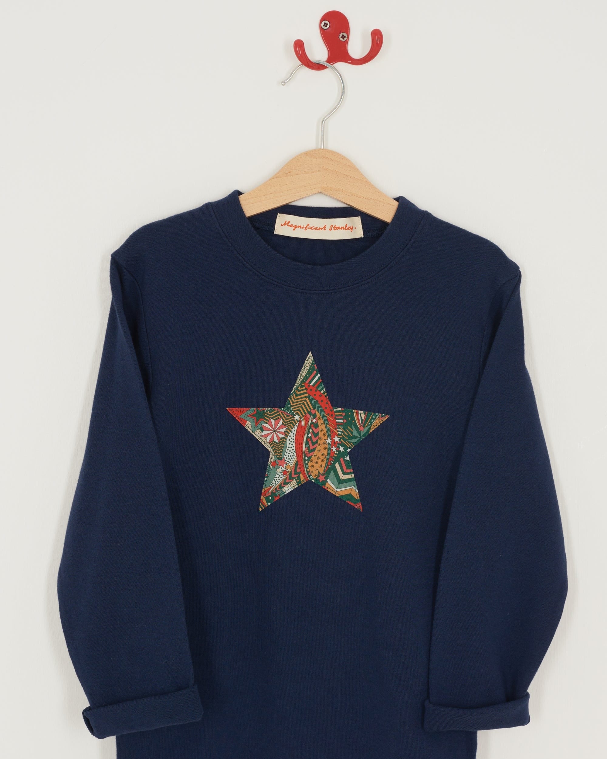 A navy long sleeve christmas t-shirt with a festive star on the front made from Liberty My Little Star print on the front.