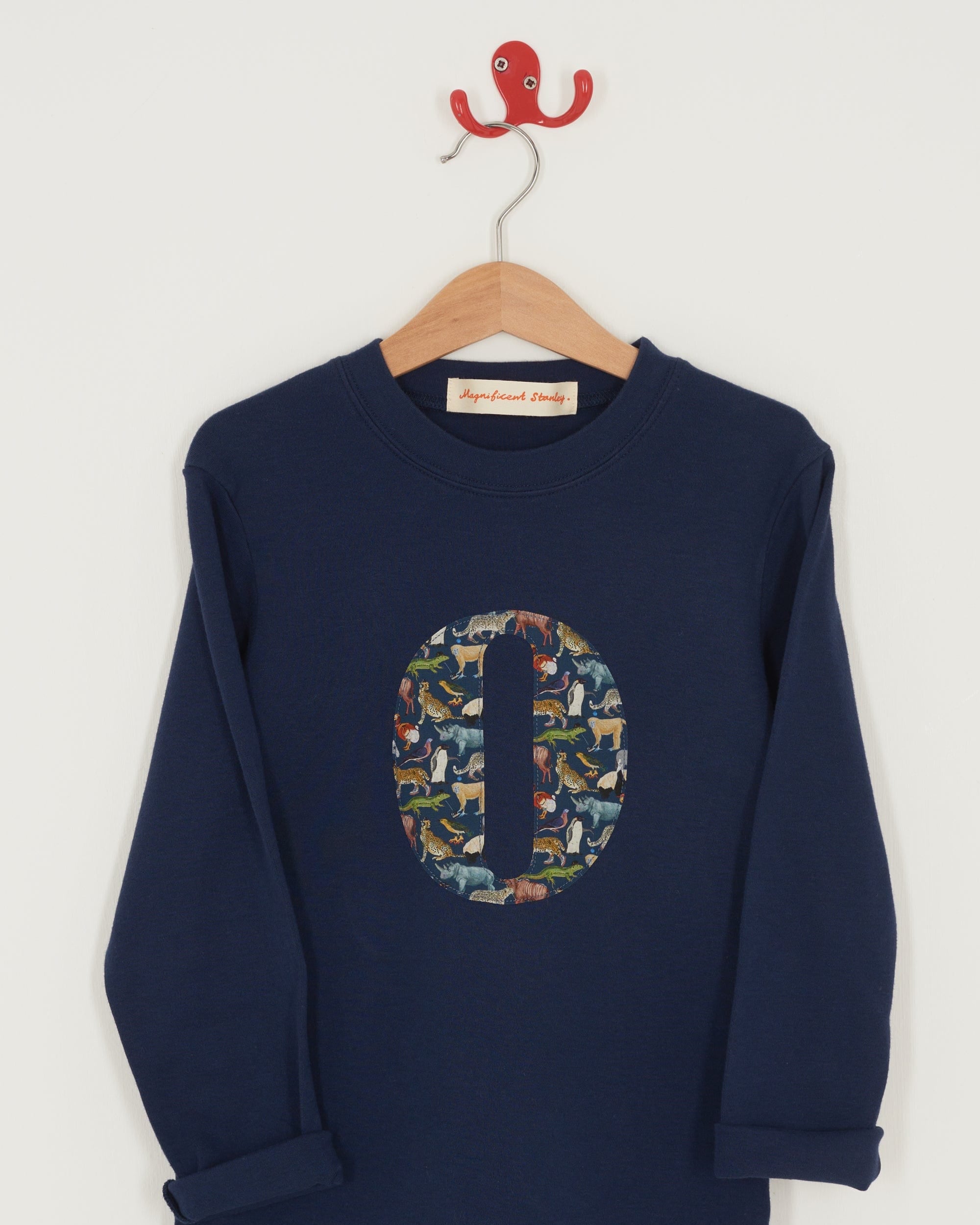 A personalised cotton navy long sleeve tee with an initial on the front made from Quey Zoo animal Liberty print fabric.