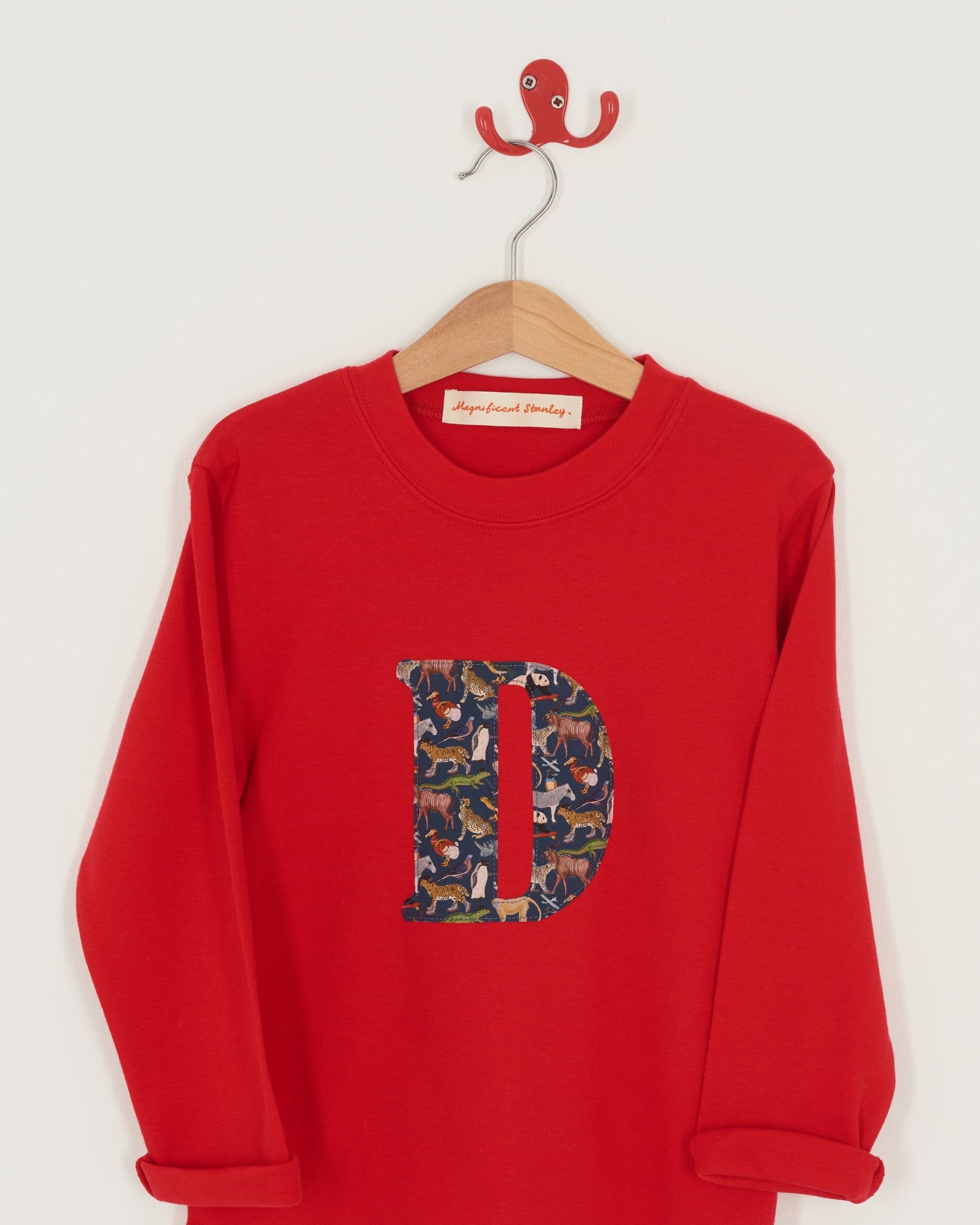 A personalised red cotton t-shirt with his initial on the front made out of a Liberty zoo animal print Quey 2.