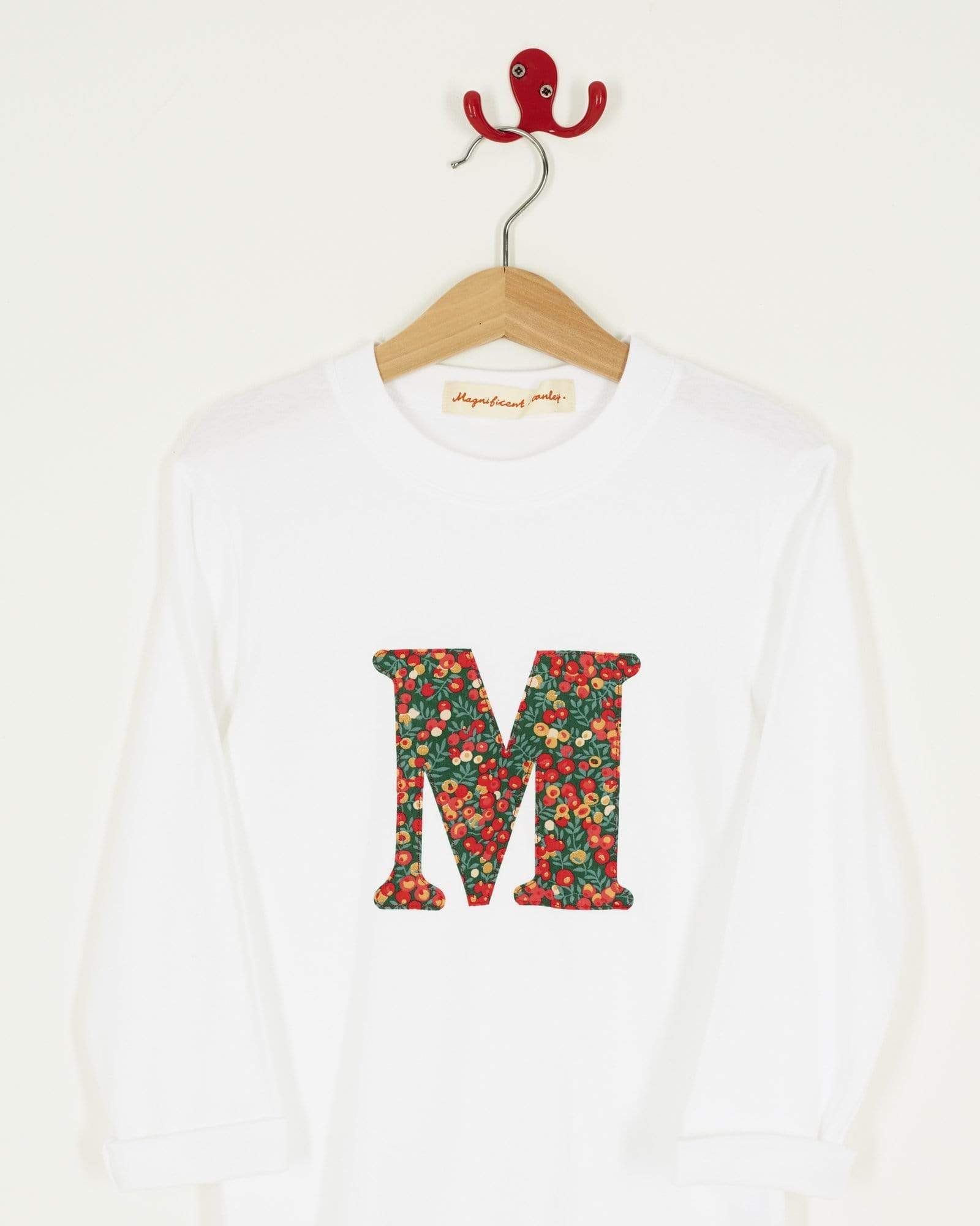 A personalised white t-shirt with a her initial on the front made from Liberty Glitter Wiltshire berry fabric.