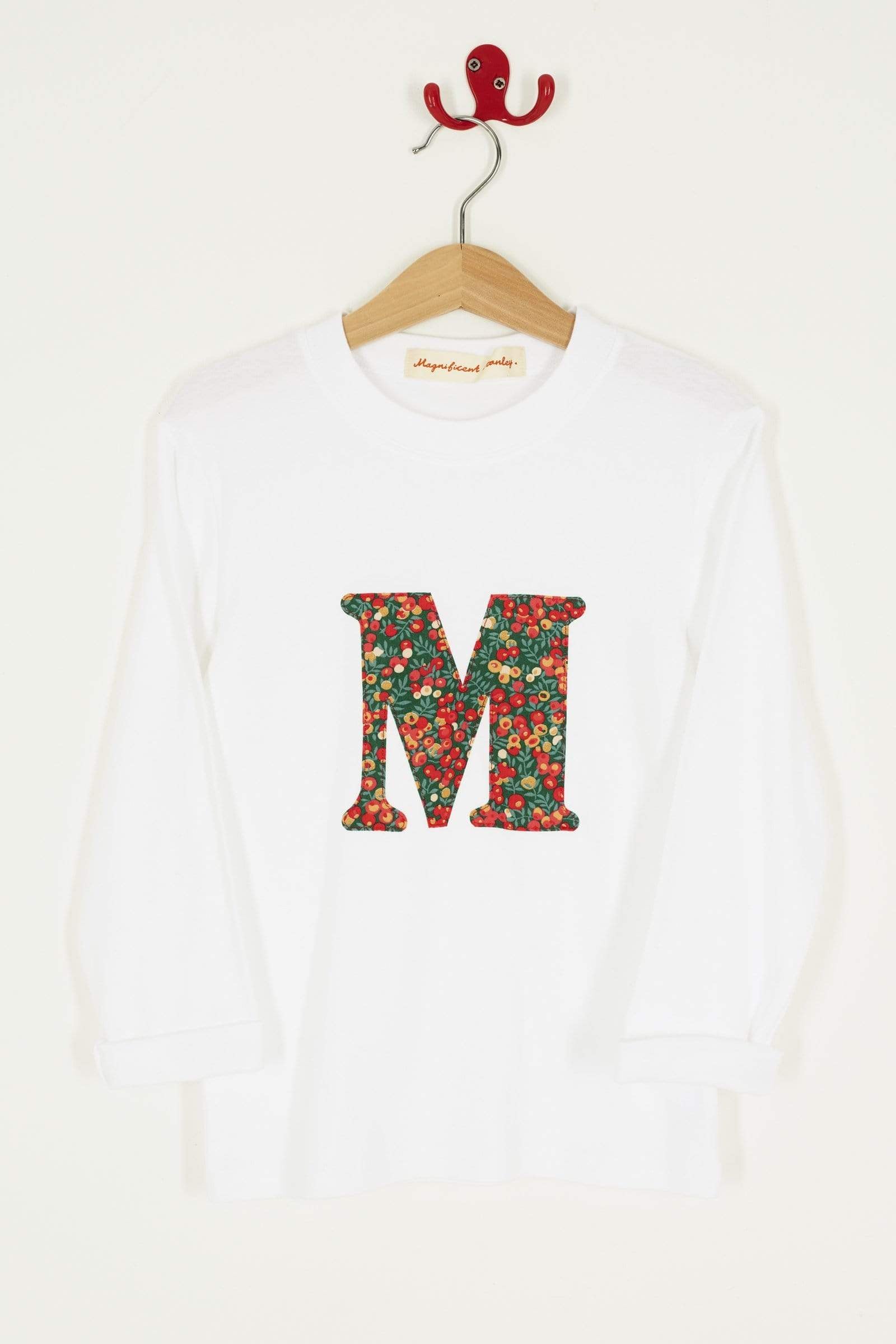 A personalised white t-shirt with a her initial on the front made from Liberty Glitter Wiltshire berry fabric.