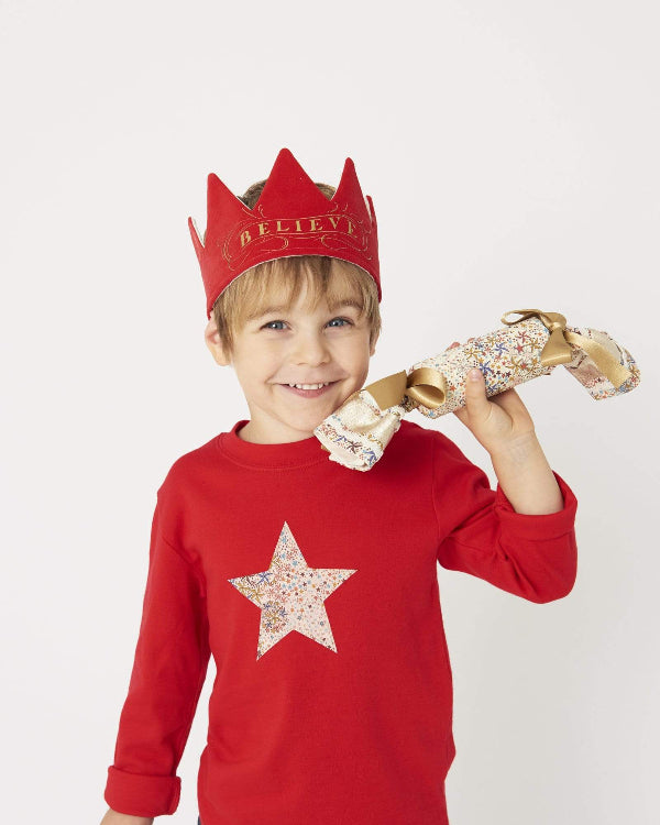 a smiling 5 year old boy wearing a Magnificent Stanley Red star kids Christmas T-Shirt in Adelajda Liberty Print