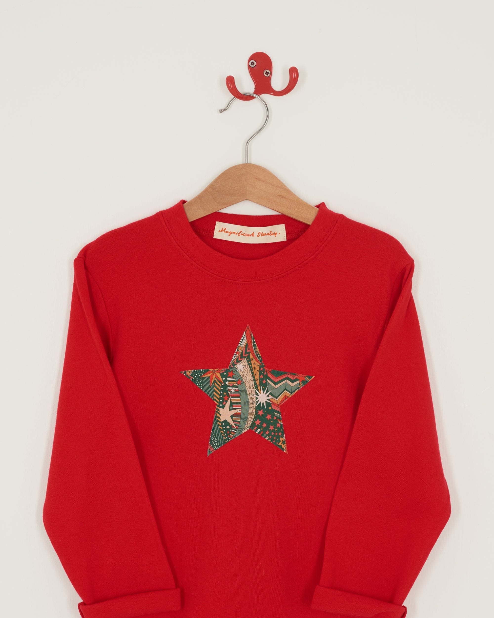 A red Christmas t-shirt with a festive star on the front in a starry Liberty print.