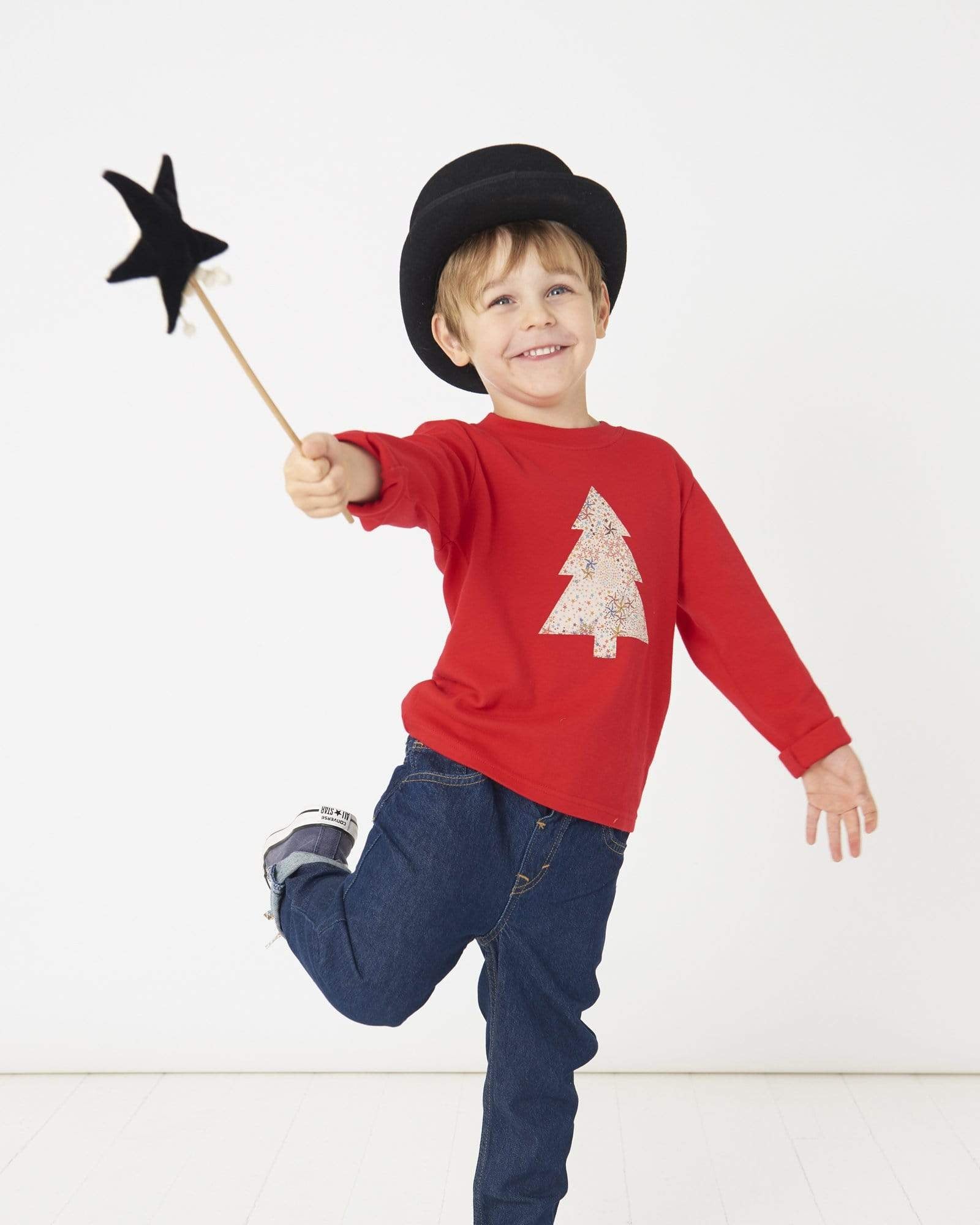 a 5 year old boy wearing a Magnificent Stanley Tee Red Tree kids Christmas T-Shirt in Adelajda Liberty Print