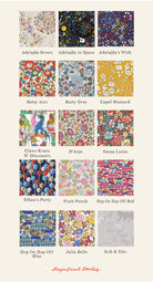A grid of 24 liberty print fabric swatches with colourful patterns and names underneath, including Adelajda Brown, Besty Ann, Capel Mustard, and others, on a light beige background. The brand name 'Magnificent Stanley' appears at the bottom. Patterns feature cars, planes, flowers, balloons, dinosaurs, stars and cats.