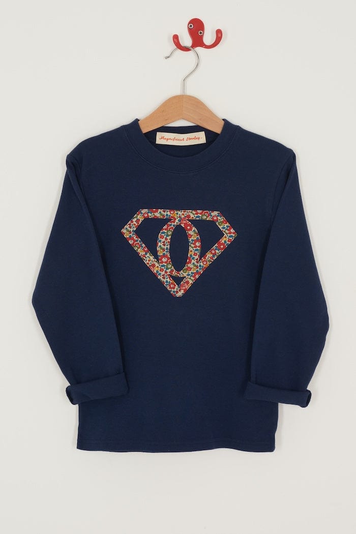 A personalised  navy t-shirt with a superhero motif initial made from floral Liberty print fabric.