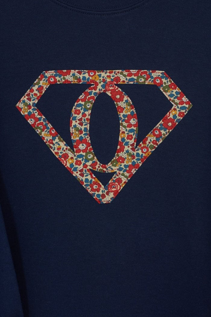 A personalised navy t-shirt with a superhero motif initial made from floral Liberty print fabric.