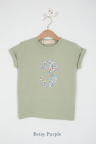 a number 3rd birthday kids sage green t-shirt with a number cut from betsy purple floral liberty print on the front.