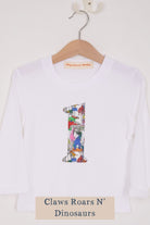 a white birthday t-shirt with a number 1 cut from liberty dinosaur print on the front