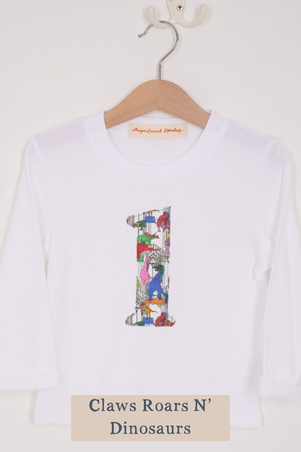 a white birthday t-shirt with a number 1 cut from liberty dinosaur print on the front