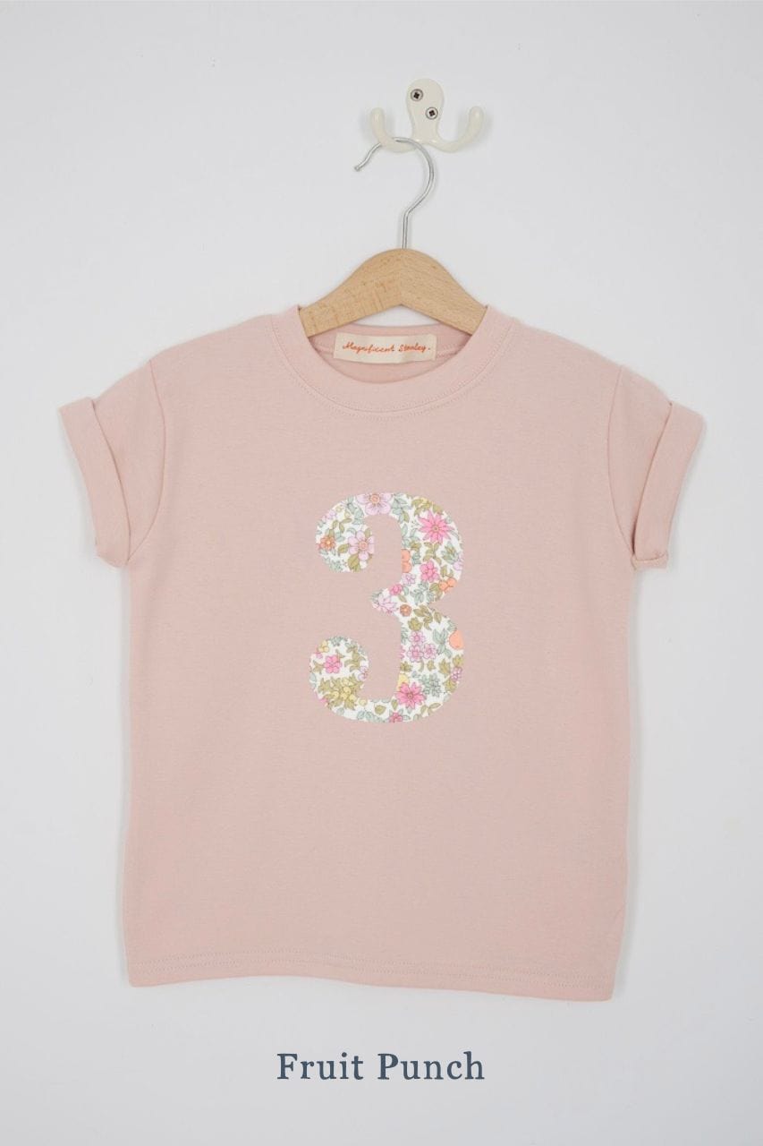 a pink 3rd birthday t-shirt with a number 3 cut from  fruit punch liberty floral print on the front