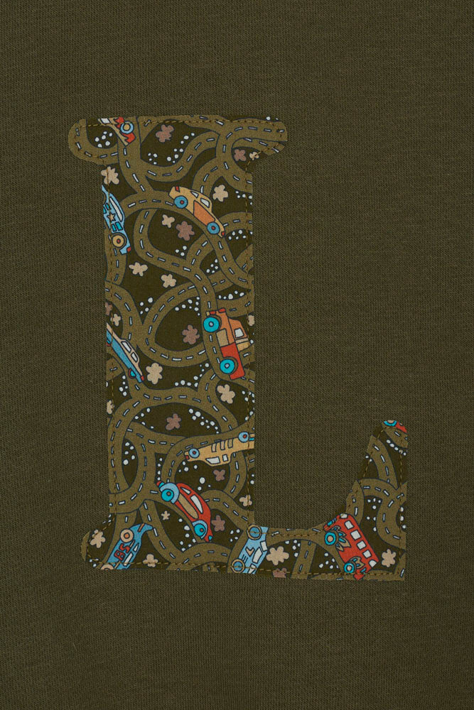 A khaki sweatshirt with an initial on the front. The initial is made from vintage cars Liberty print.