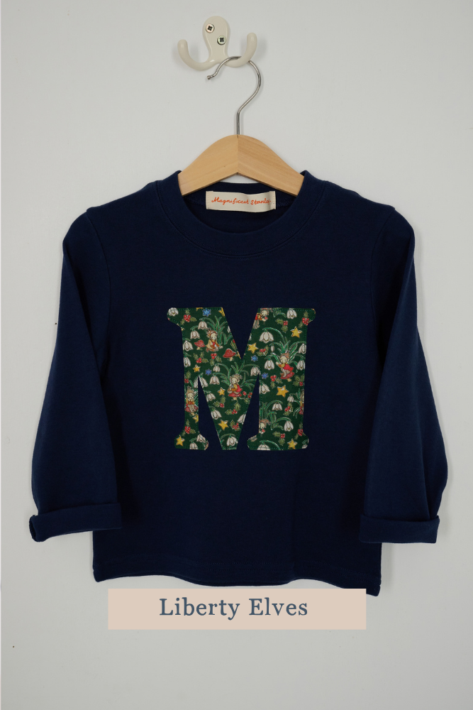 a navy cotton t-shirt with the letter 'c' on the front cut from festive Liberty Elves liberty print
