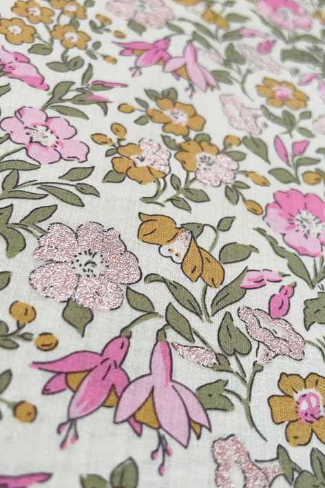 A close up of Liberty Mamie floral print enhanced with a delicate metallic overlay