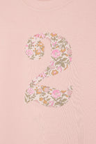 a 2 year old birthday girl wearing a pale pink t-shirt with the number 2 sewn on the front cut from liberty floral Mamie print.