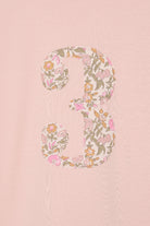 a pale pink t-shirt with the number 3 sewn on the front cut from liberty floral Mamie print.