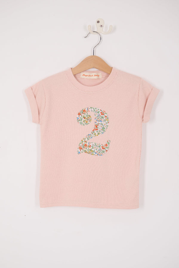 A Pink t-shirt with a Liberty Nazanin floral number '2' on a hanger against a white background